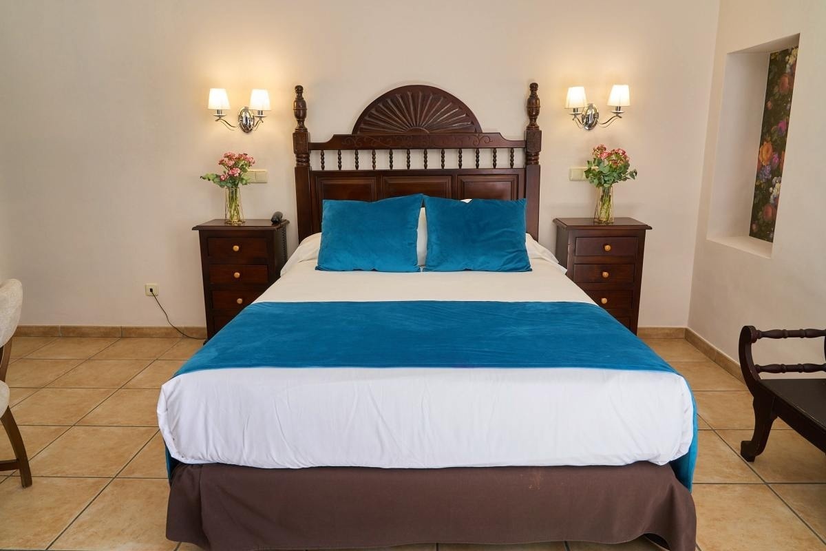 una habitación con una cama y dos mesitas de noche