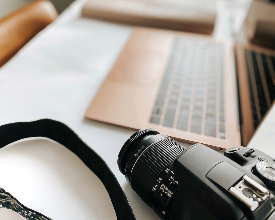 a camera is sitting on a table next to a laptop