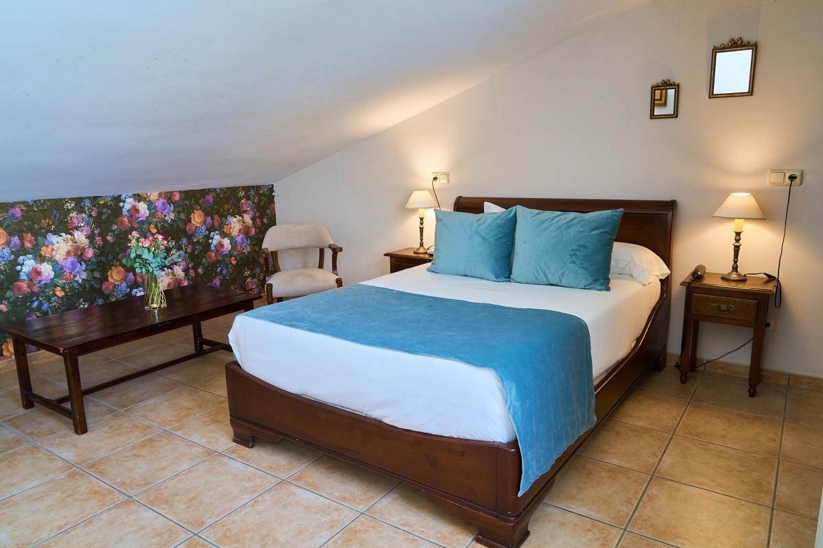 una habitación con una cama y dos mesitas de noche