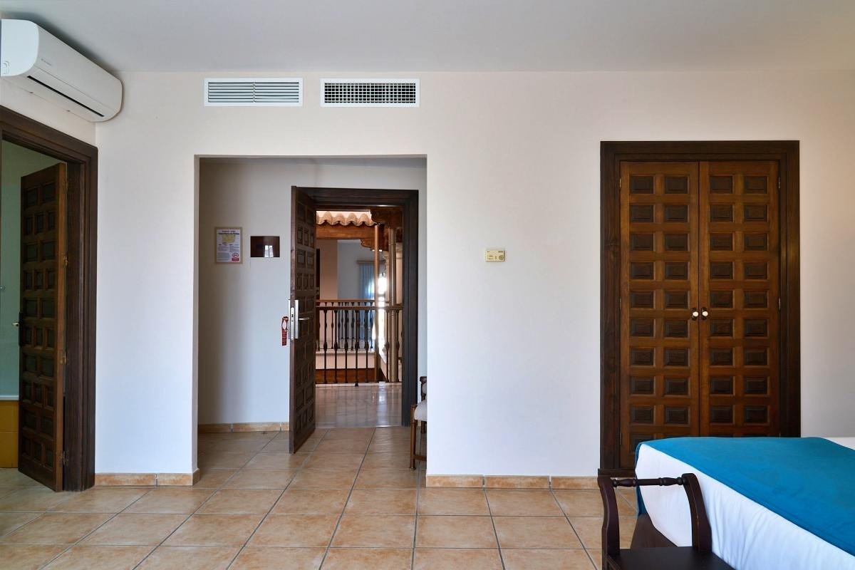 una habitación con una cama y una puerta de madera