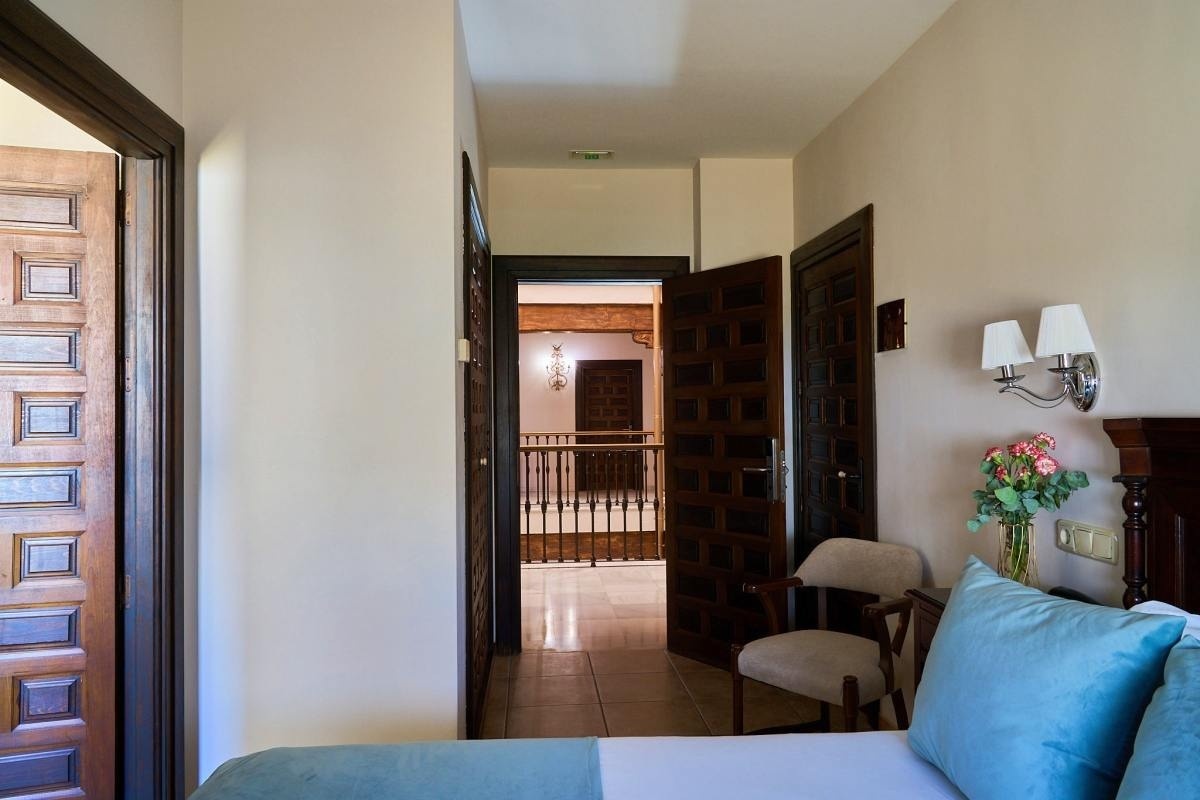 una cama y una silla en una habitación con una puerta abierta