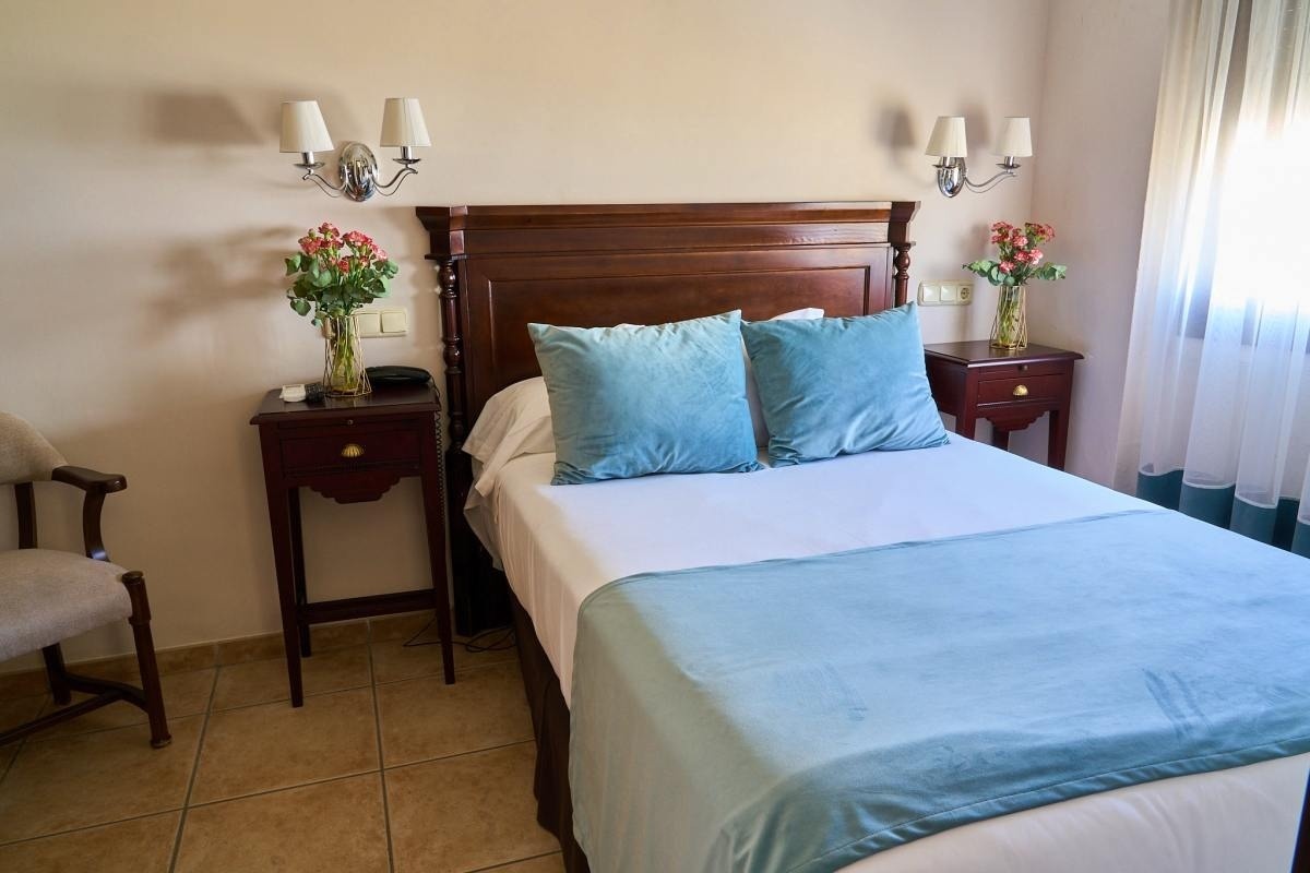 una habitación con una cama y dos mesitas de noche