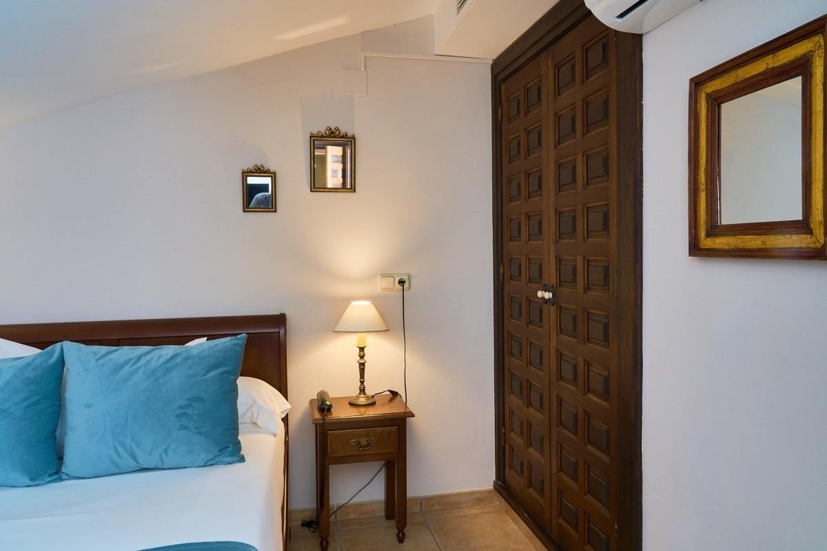 un dormitorio con una cama y un espejo en la pared