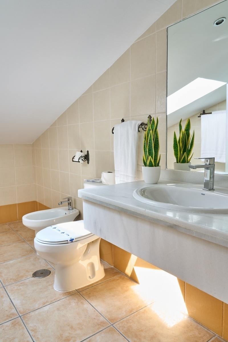 un baño con dos inodoros y un lavabo