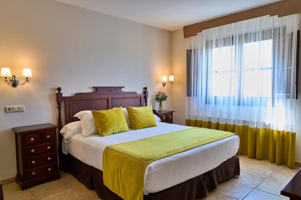 una habitación con una cama y dos mesitas de noche