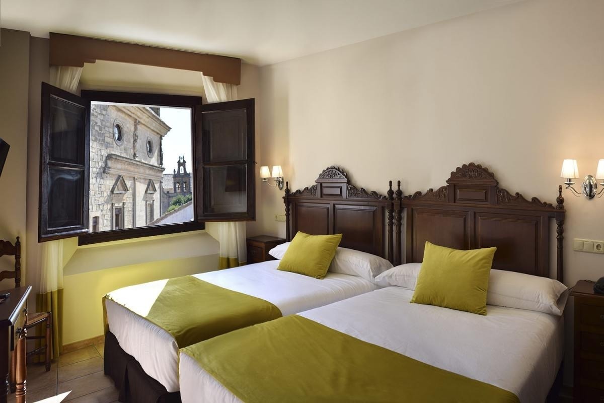 una cama y una silla en una habitación con una puerta abierta