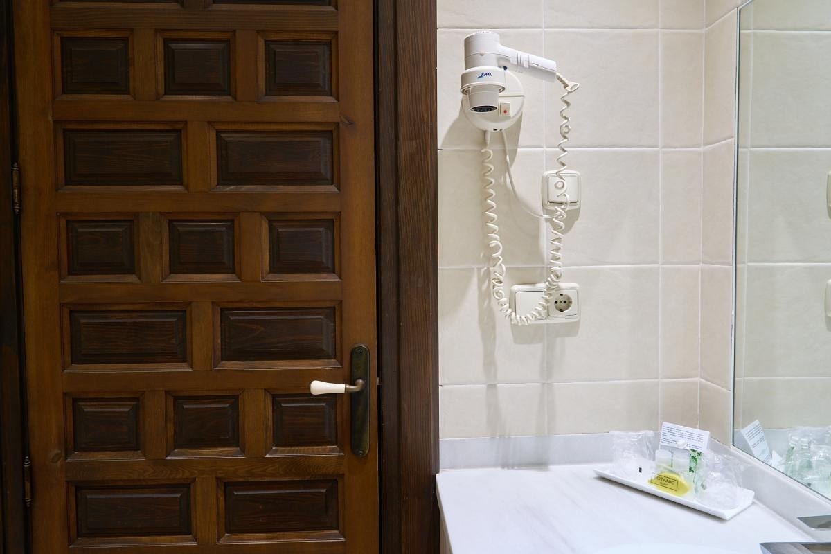 una puerta de madera y un secador de pelo en un baño