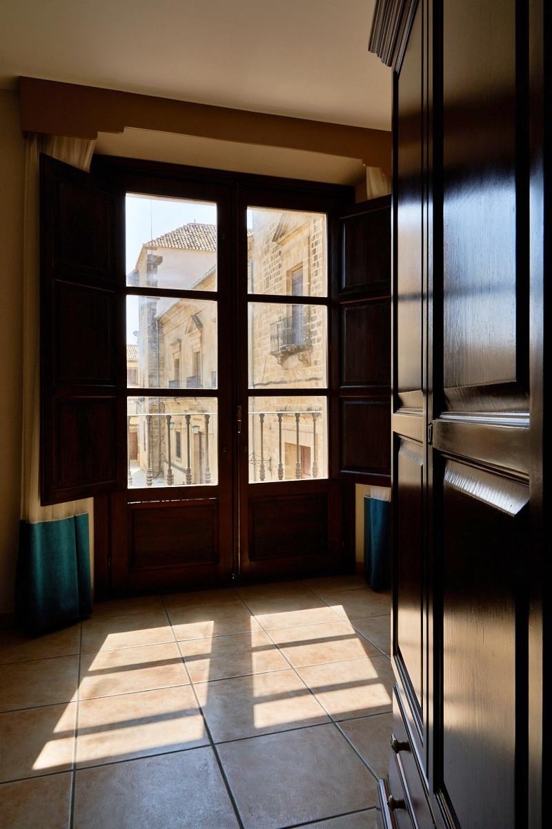 una habitación vacía con una ventana abierta y una puerta de madera