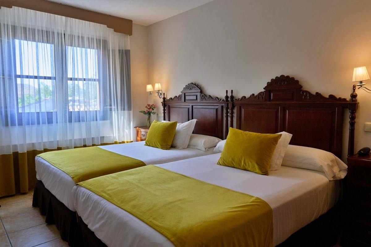 una habitación de hotel con dos camas y una ventana