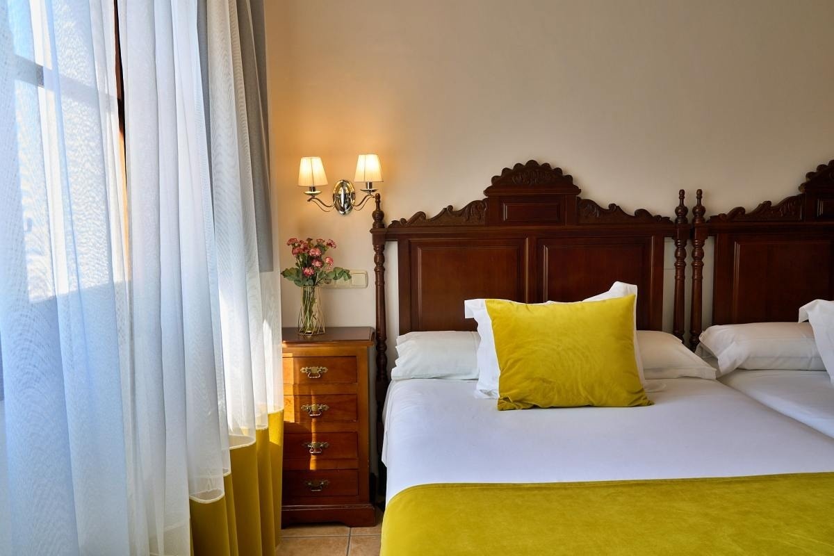 una habitación con dos camas y una mesita de noche