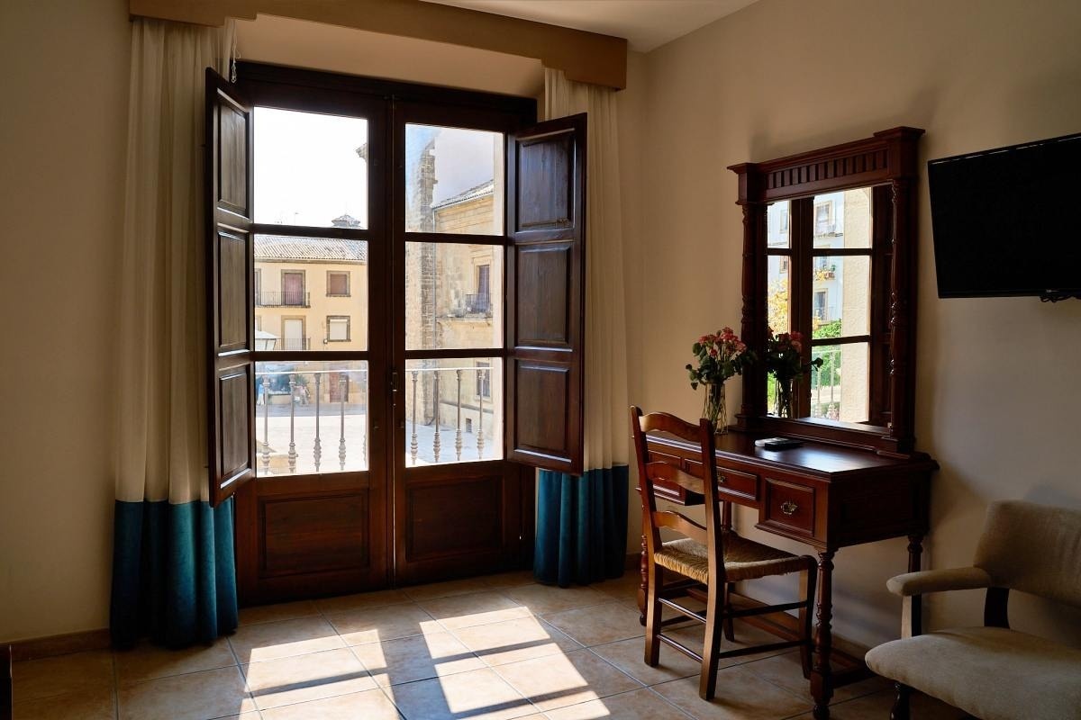 una cama y una silla en una habitación con una puerta abierta