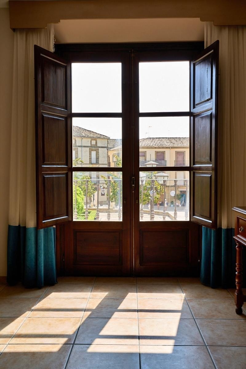 una habitación con una ventana abierta y cortinas azules