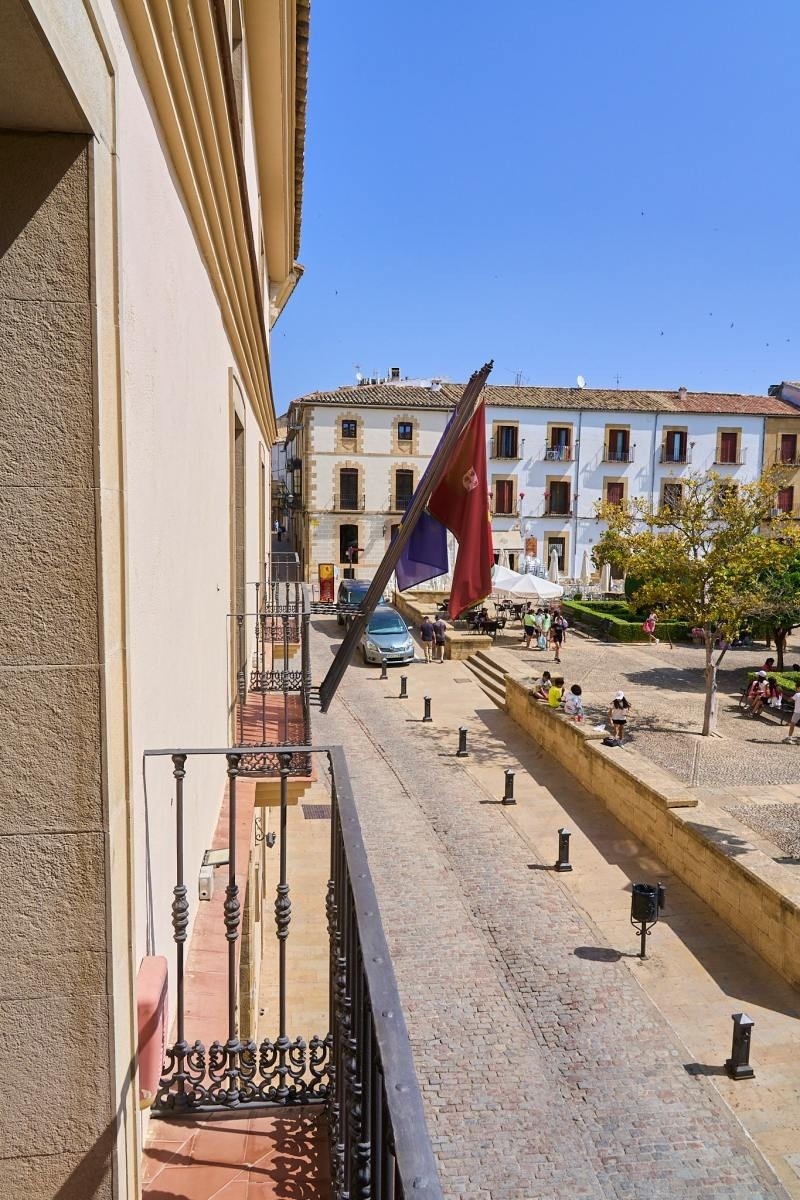 una bandera roja y morada ondea en un balcón
