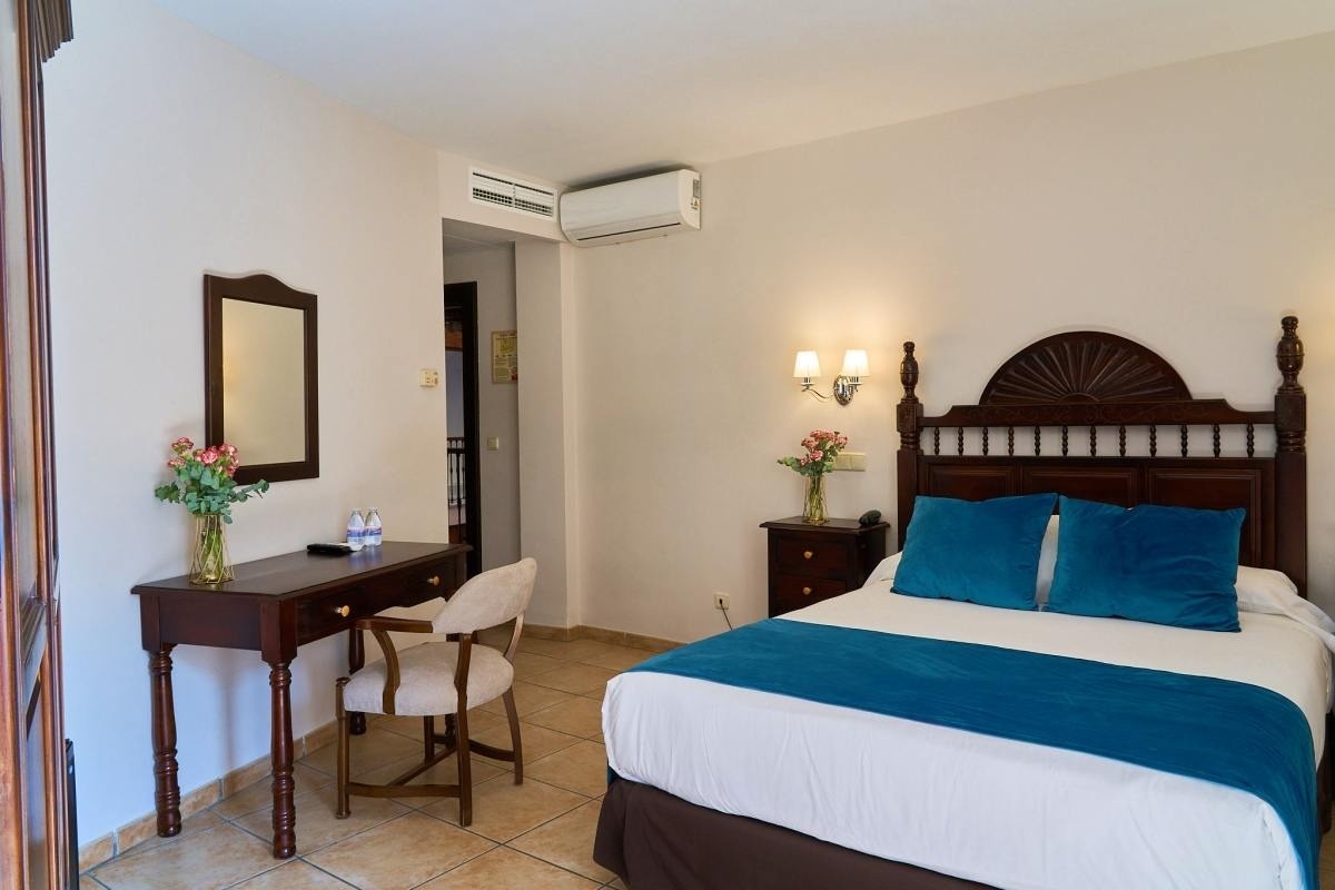 una habitación de hotel con una cama y un escritorio