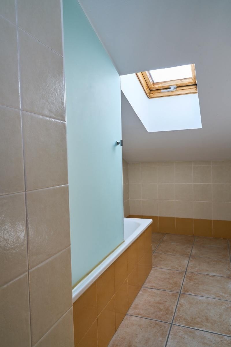 un baño con una bañera y una ventana en el techo