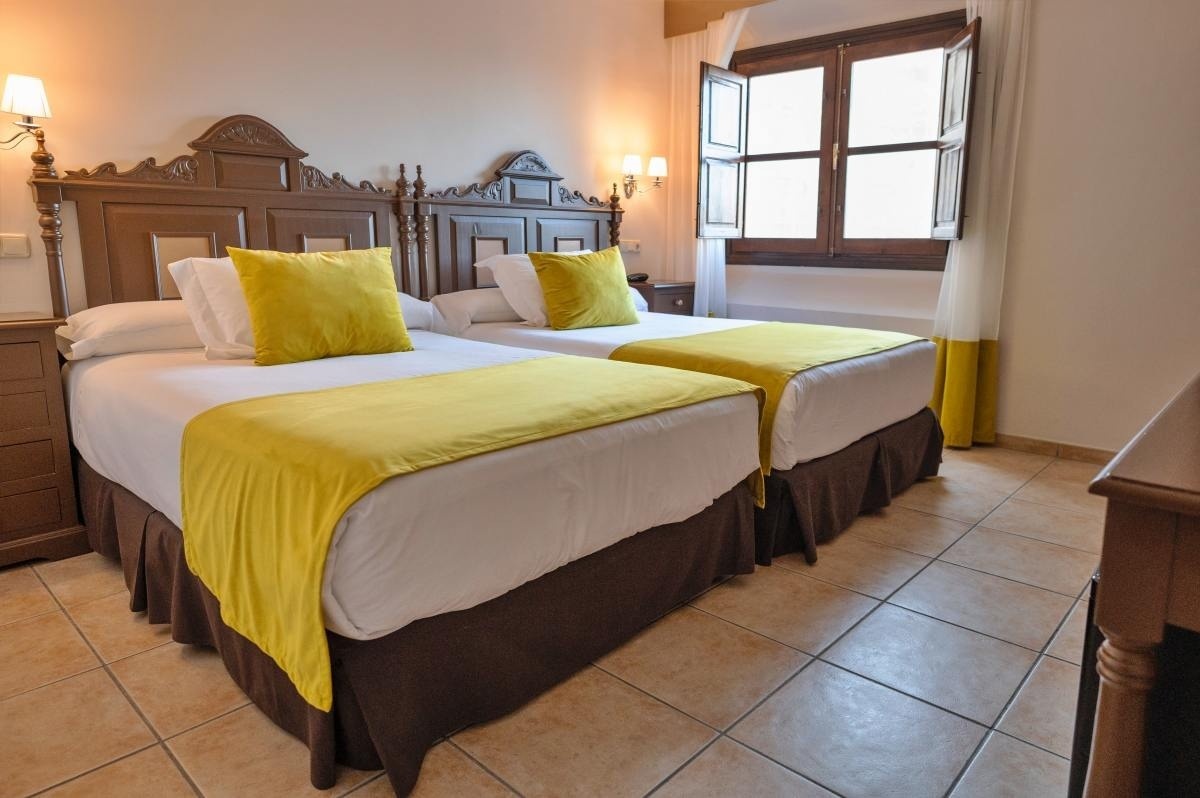 una habitación con dos camas y una ventana