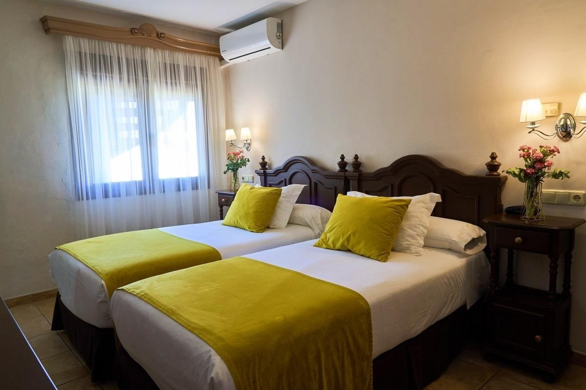 una habitación con dos camas y una ventana