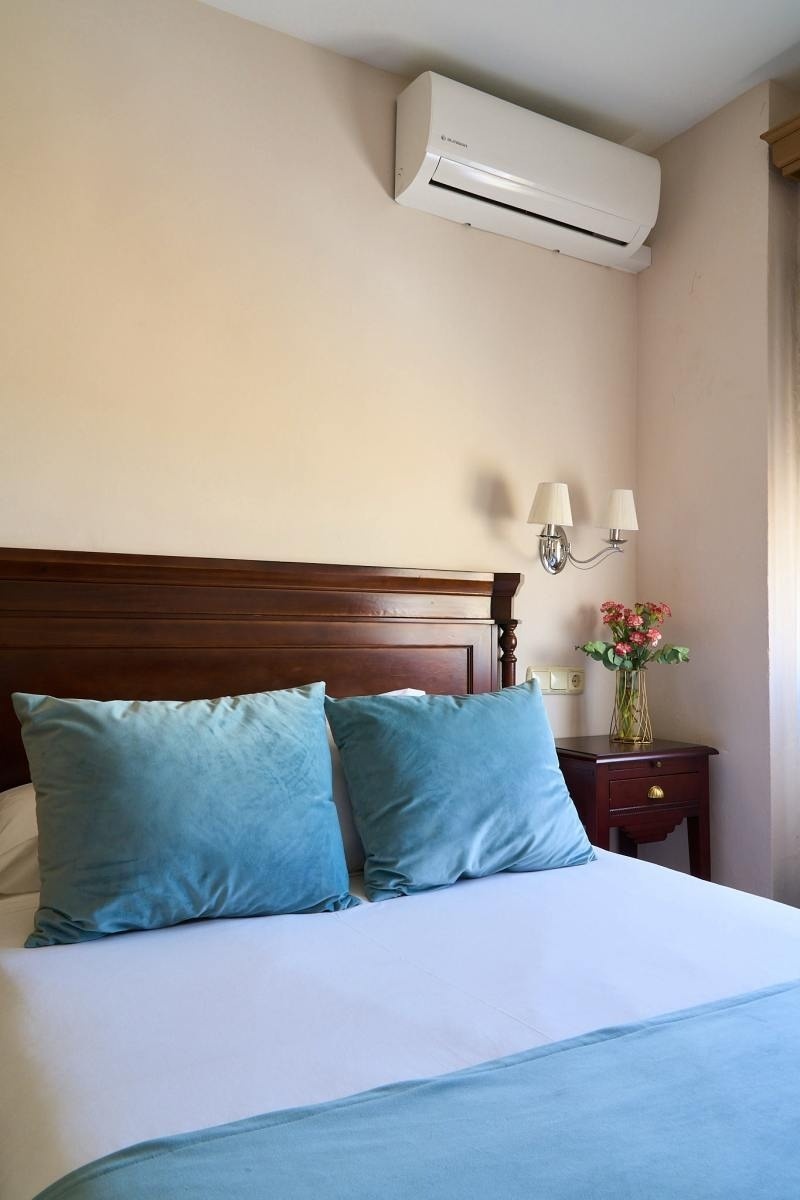 una habitación con una cama y un aire acondicionado