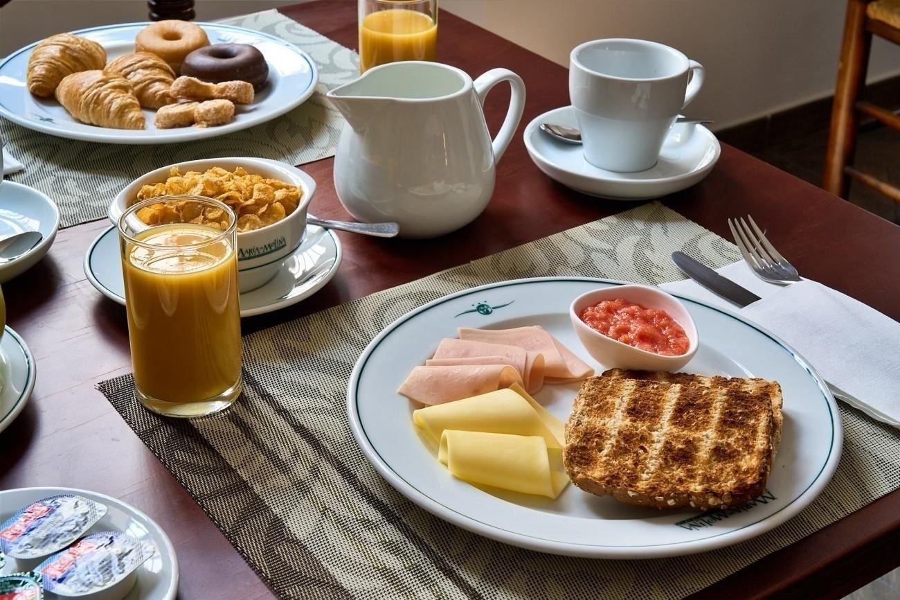 a table with a bowl of cereal and a pitcher of orange juice