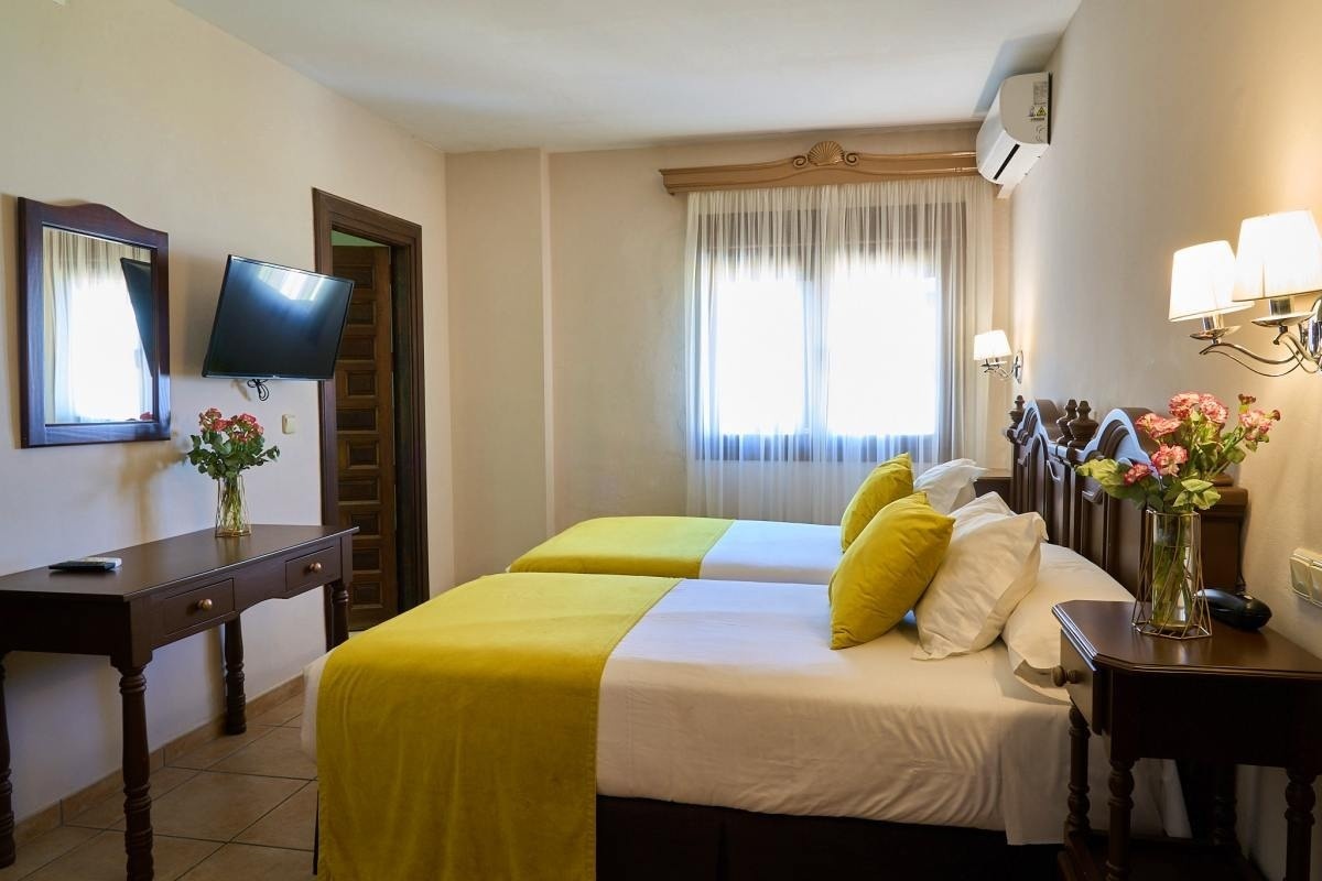 una cama y una silla en una habitación con una puerta abierta