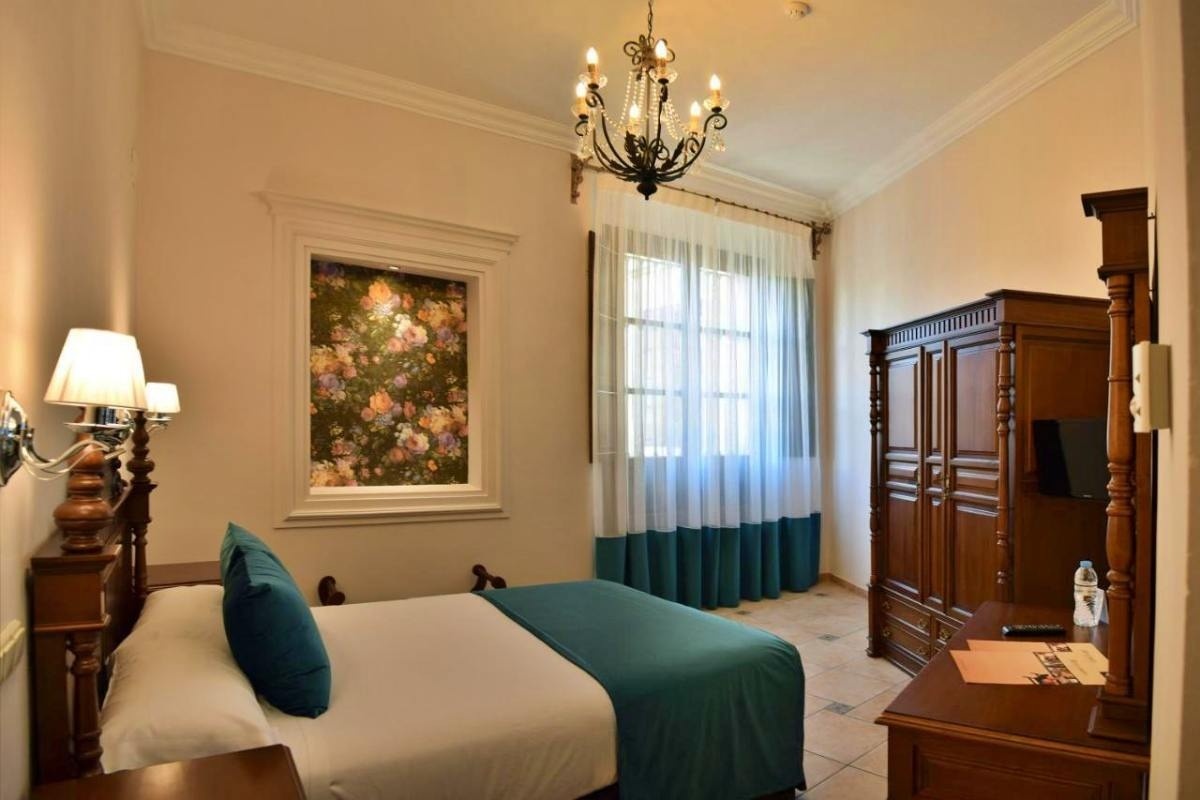 una cama y una silla en una habitación con una puerta abierta