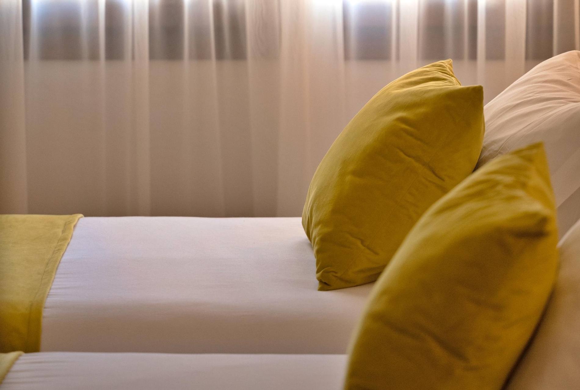 a bed with yellow pillows and white sheets