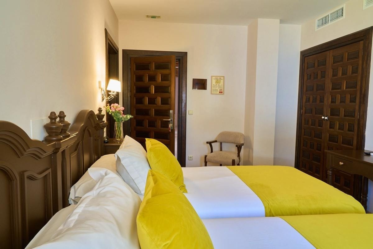 una habitación de hotel con dos camas y una puerta de madera