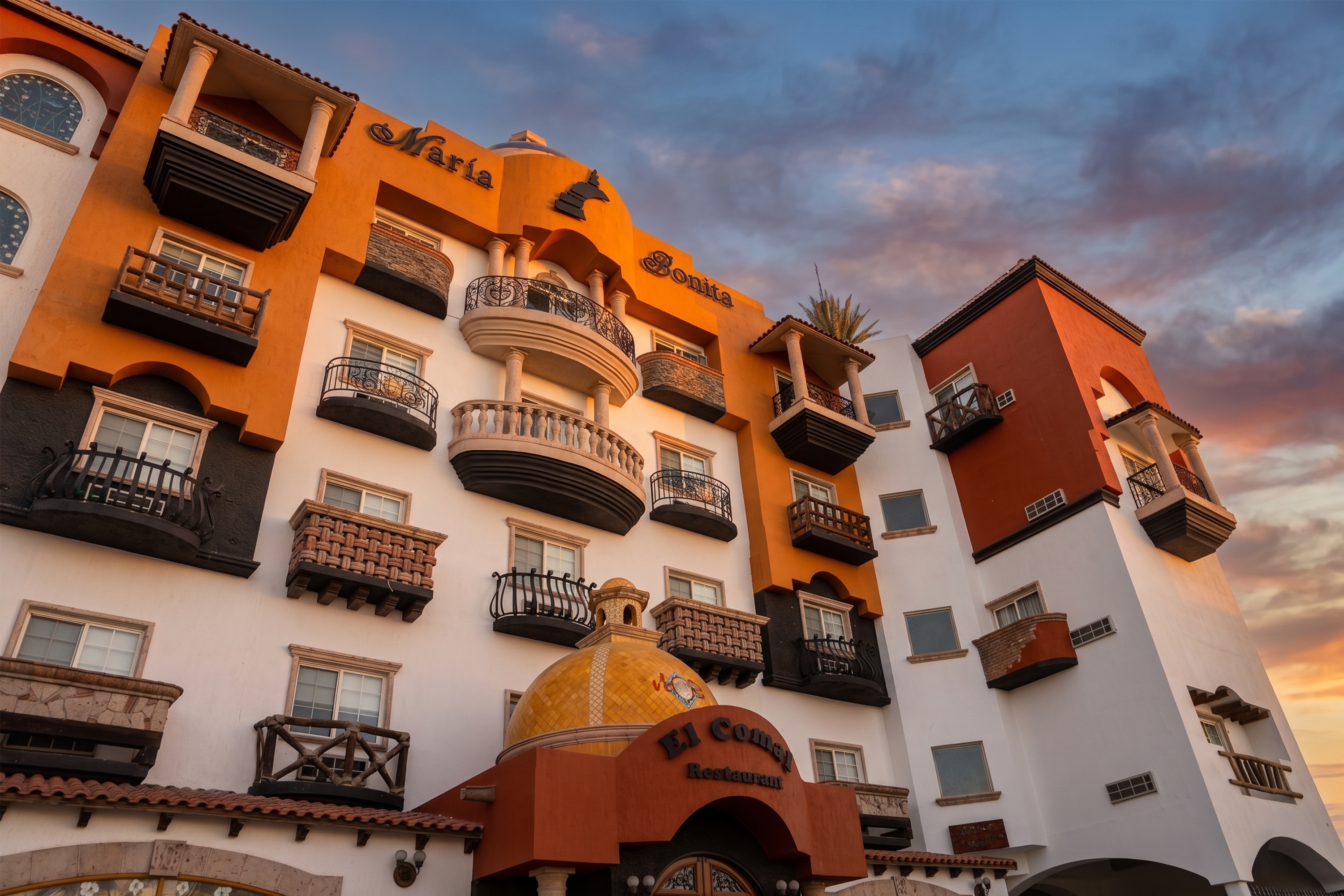 Hotel Maria Bonita Corporativa: fachada naranja y blanca con balcones.