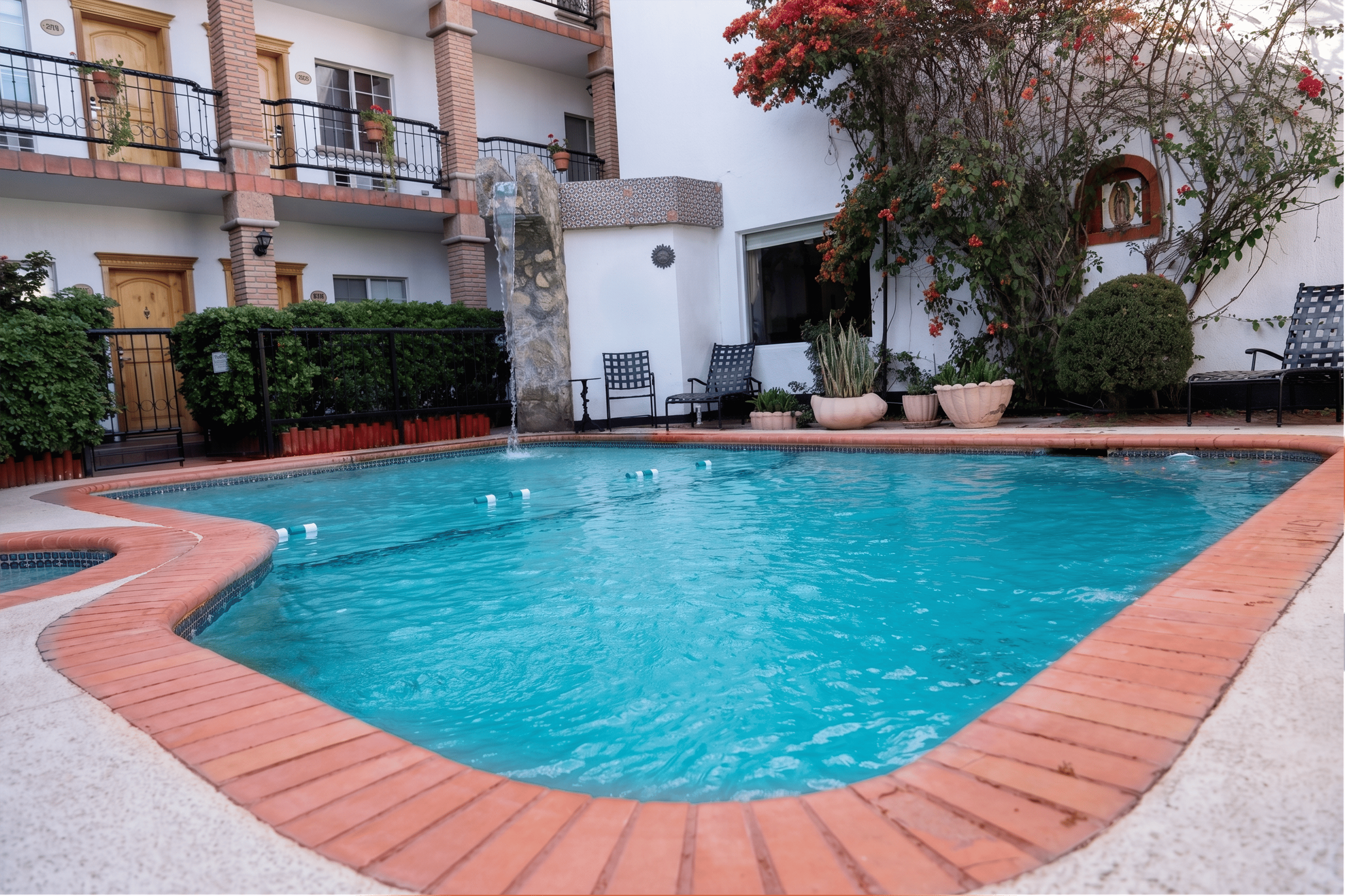 Piscina azul con borde de ladrillo, ideal para relajarse en Hotel María Bonita Corporativa.
