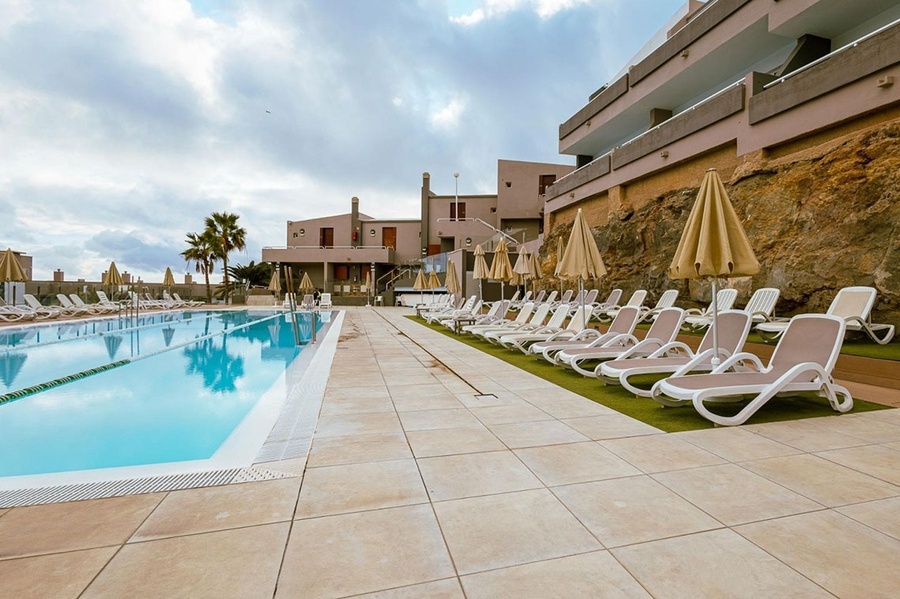 a row of lounge chairs and umbrellas on a deck