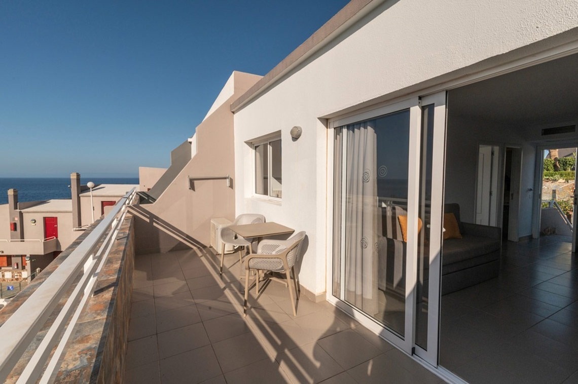 ein Balkon mit einem Tisch und Stühlen und einer Schiebetür