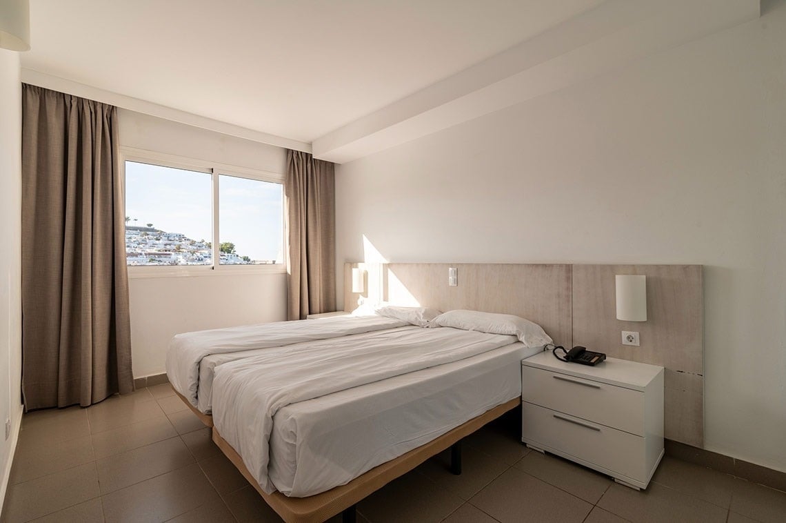 ein Schlafzimmer mit zwei Betten und einem Nachttisch