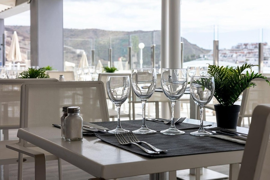 a restaurant with tables and chairs under an awning