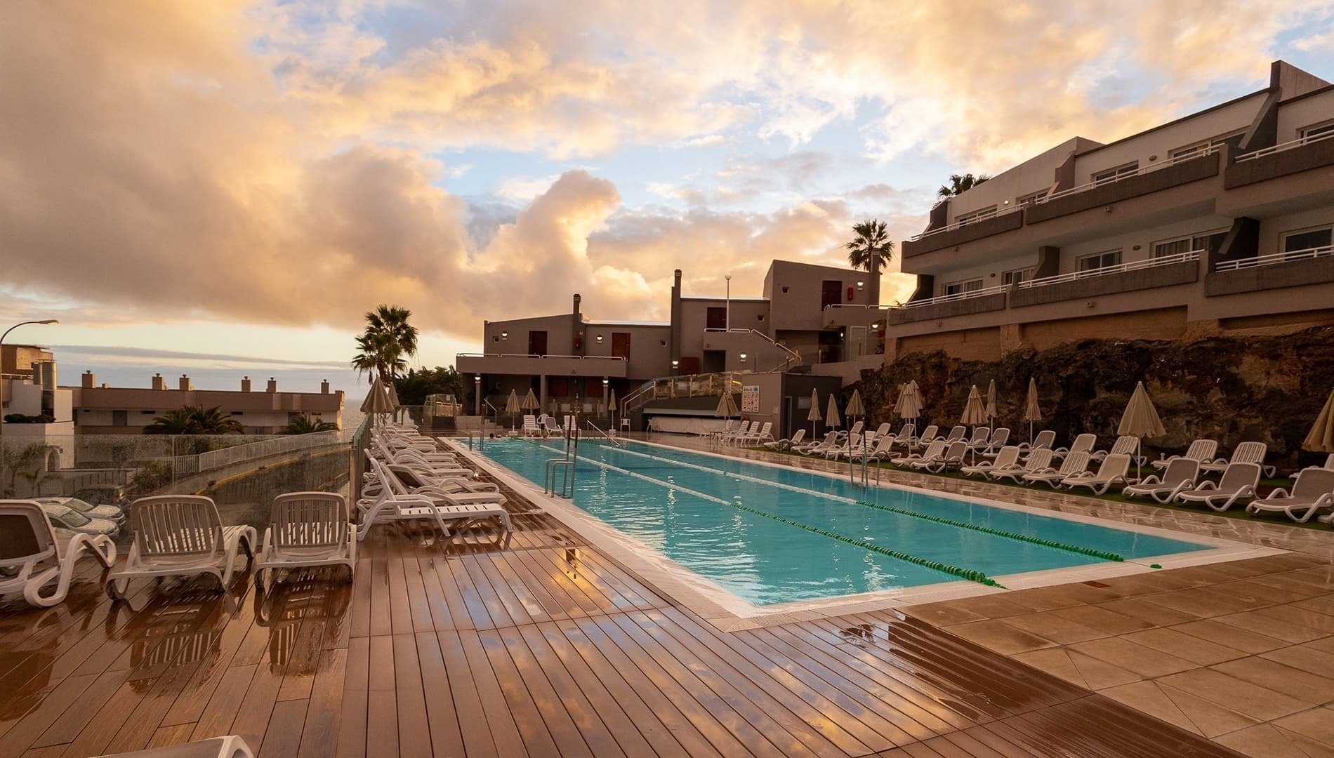 una gran piscina rodeada de sillas y sombrillas