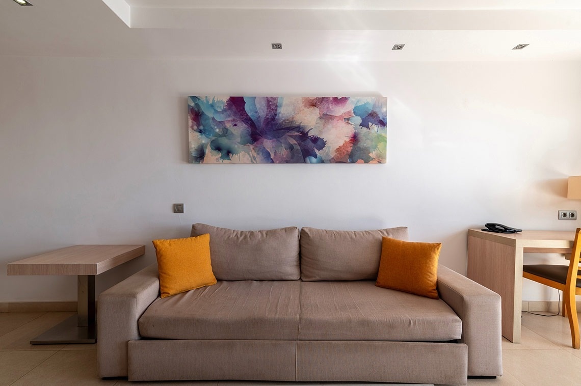 ein Wohnzimmer mit einer Couch und einem Gemälde an der Wand