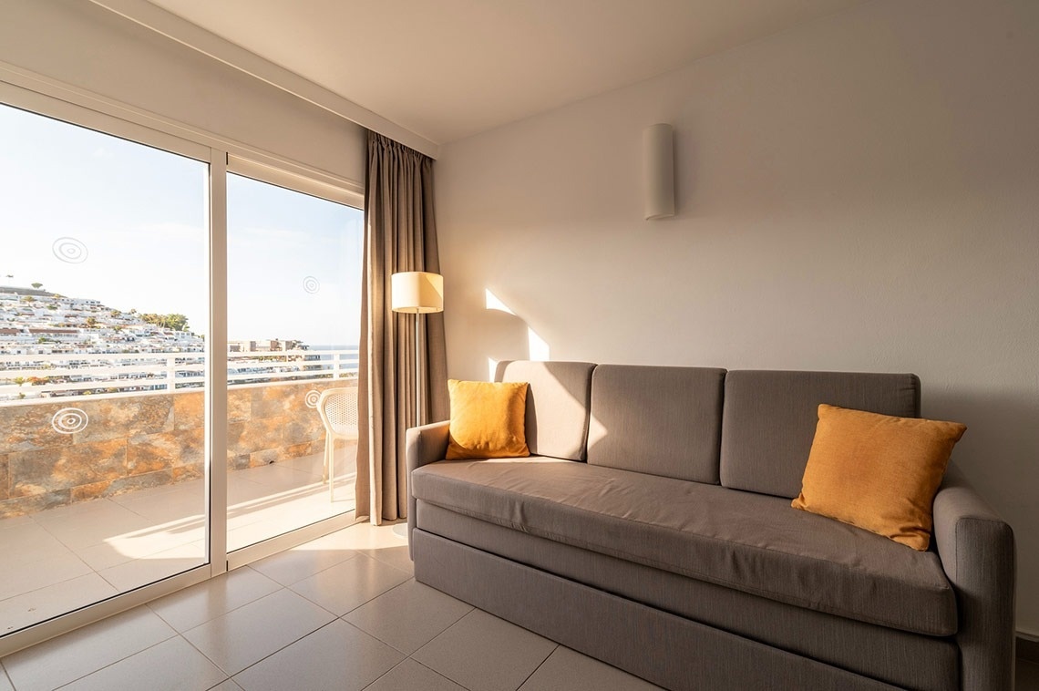 ein Wohnzimmer mit einer Couch und einem Balkon