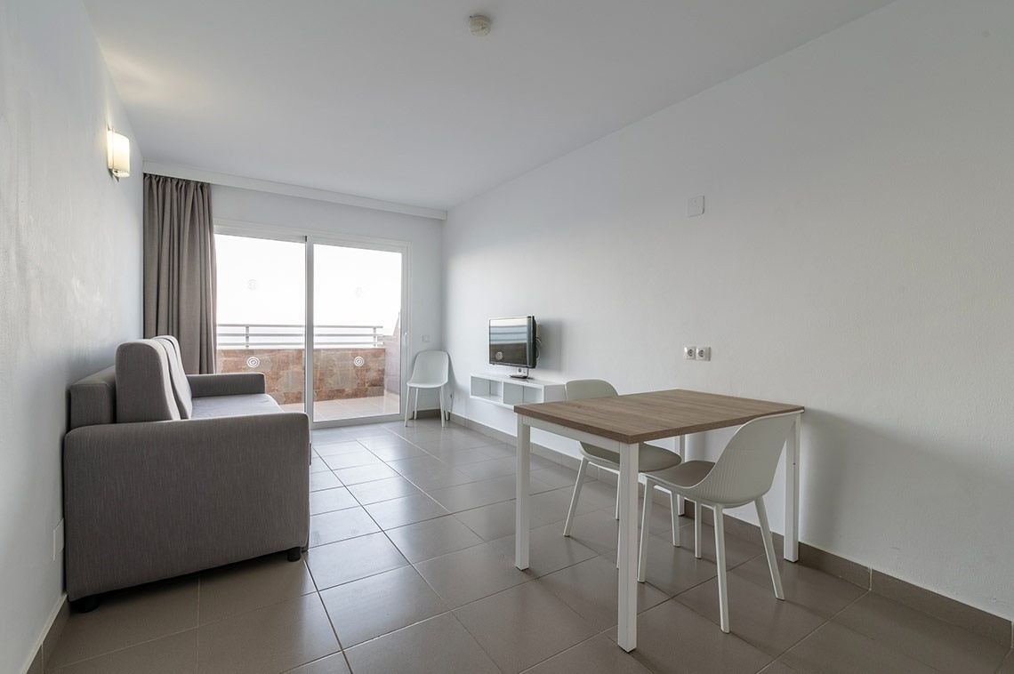 una habitación con un sofá y una mesa y sillas