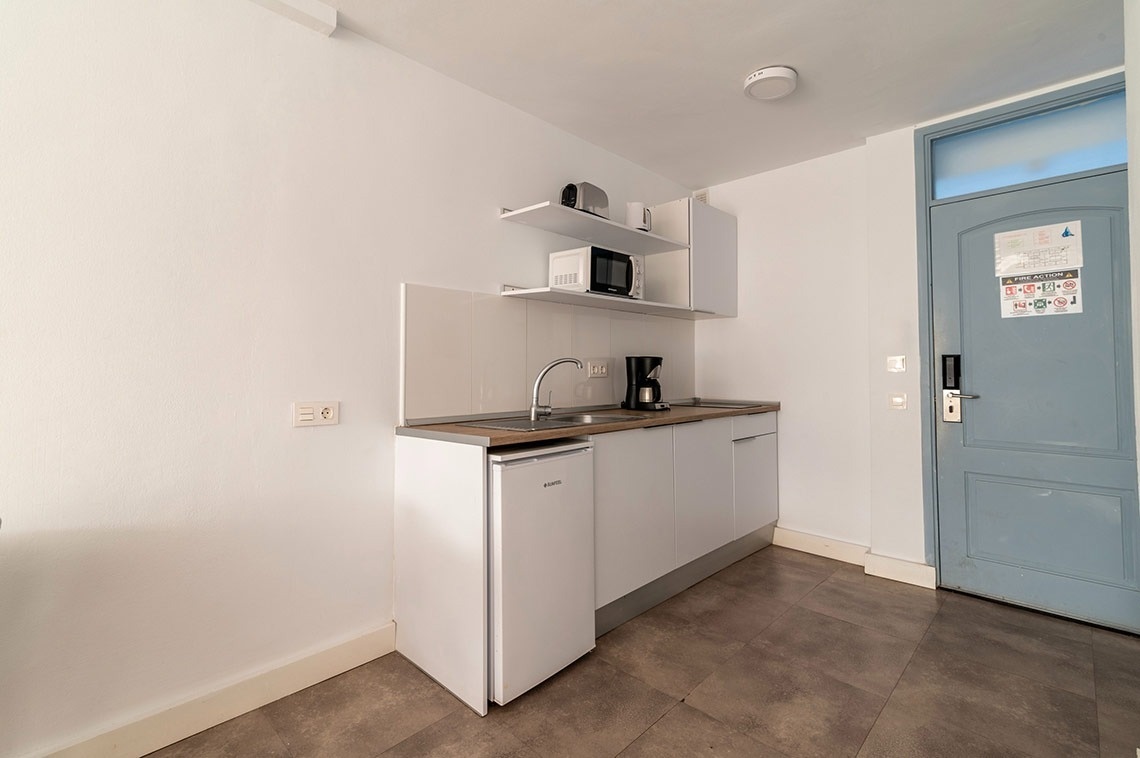 eine kleine Küche mit einem kleinen Kühlschrank und einem Mikrowellenherd