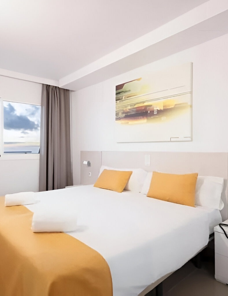 ein Schlafzimmer mit zwei Betten und einem weißen Kleiderschrank