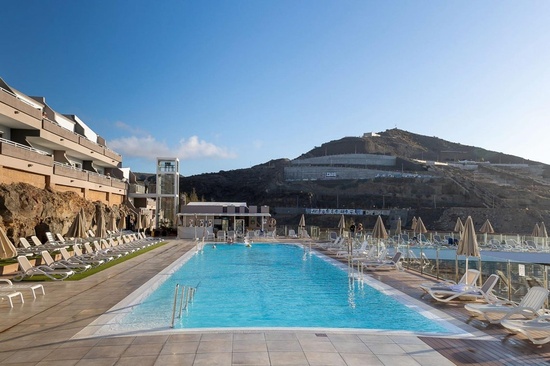 a large swimming pool is surrounded by chairs and umbrellas with the word church in the background