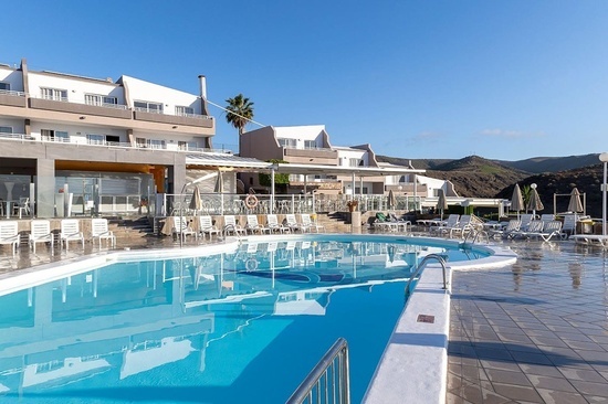 a large swimming pool in front of a hotel