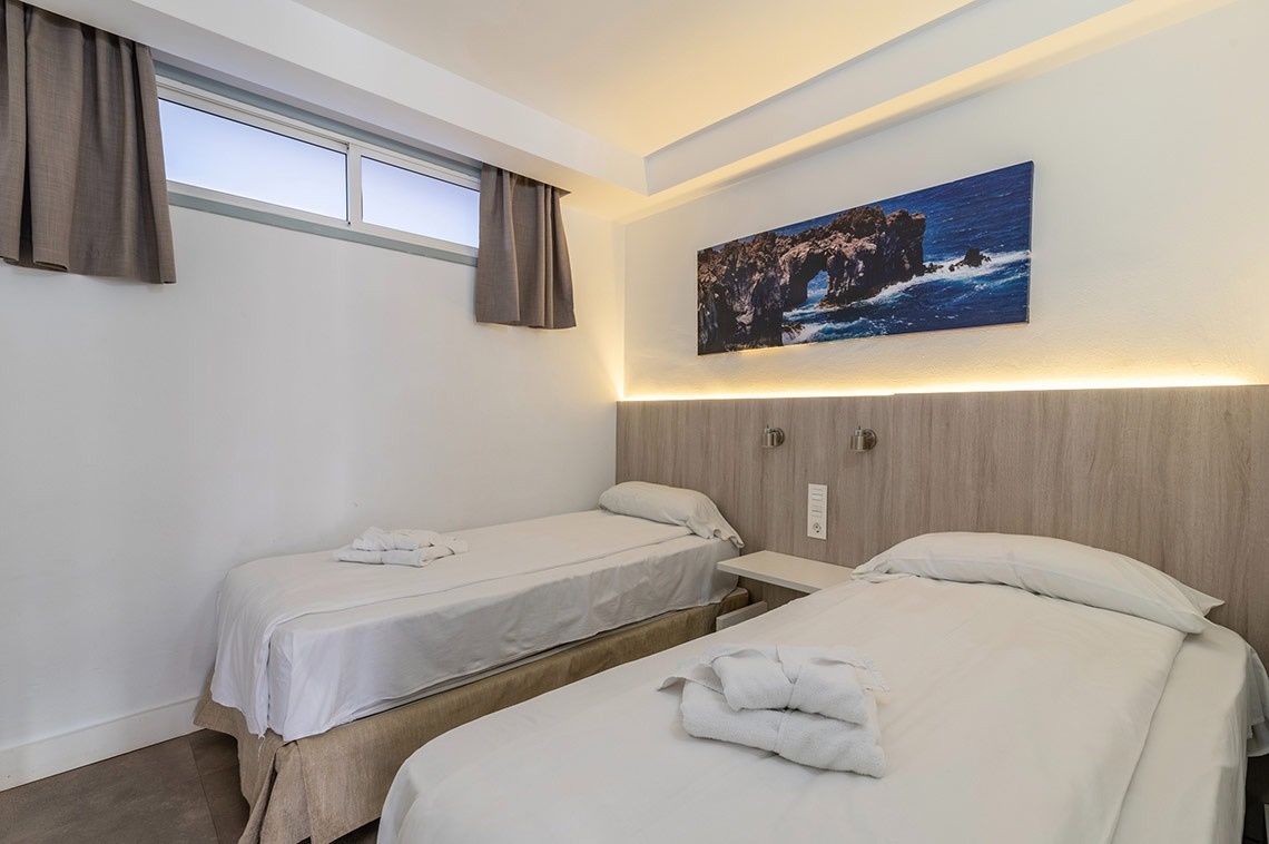 ein Schlafzimmer mit zwei Einzelbetten und einem Gemälde an der Wand