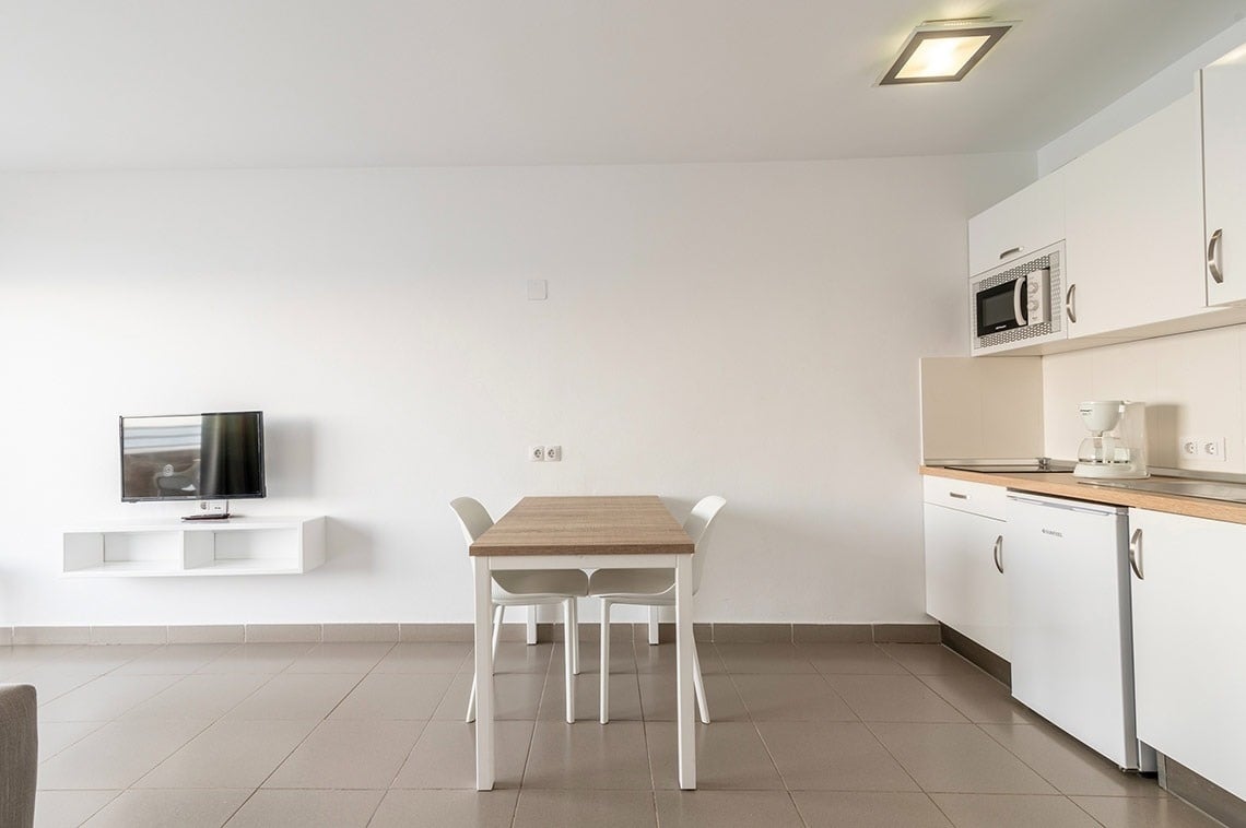 una cocina con una mesa y sillas y un televisor