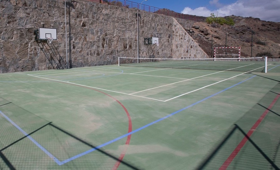 a tennis court with a net and a basketball hoop