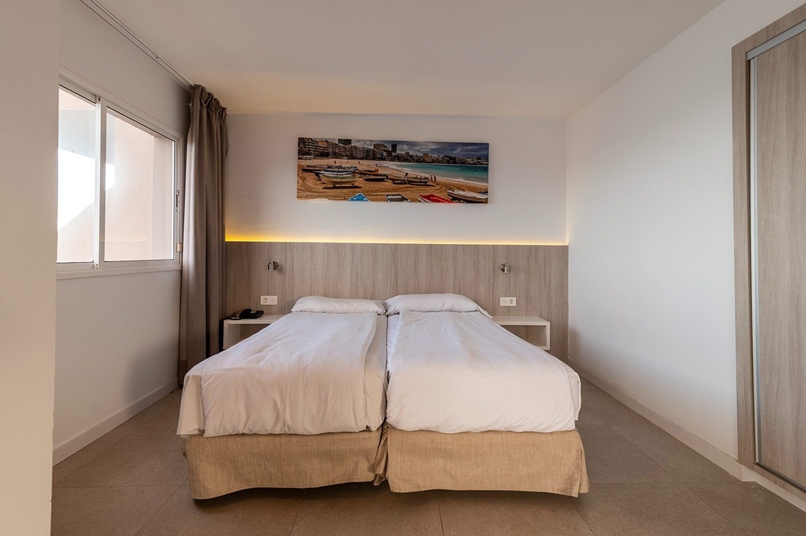 ein Schlafzimmer mit zwei Betten und einem Gemälde an der Wand