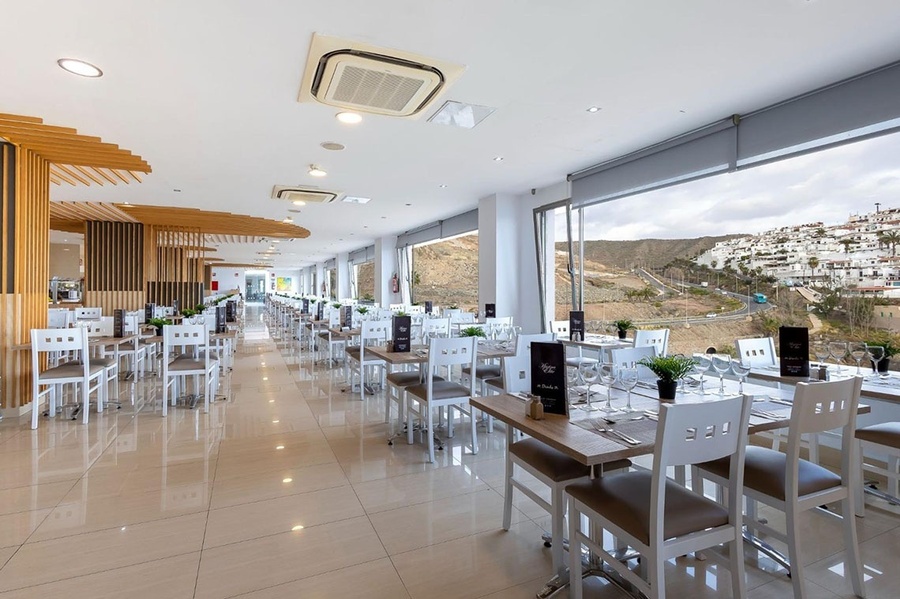 a restaurant with tables and chairs and a fire extinguisher on the wall