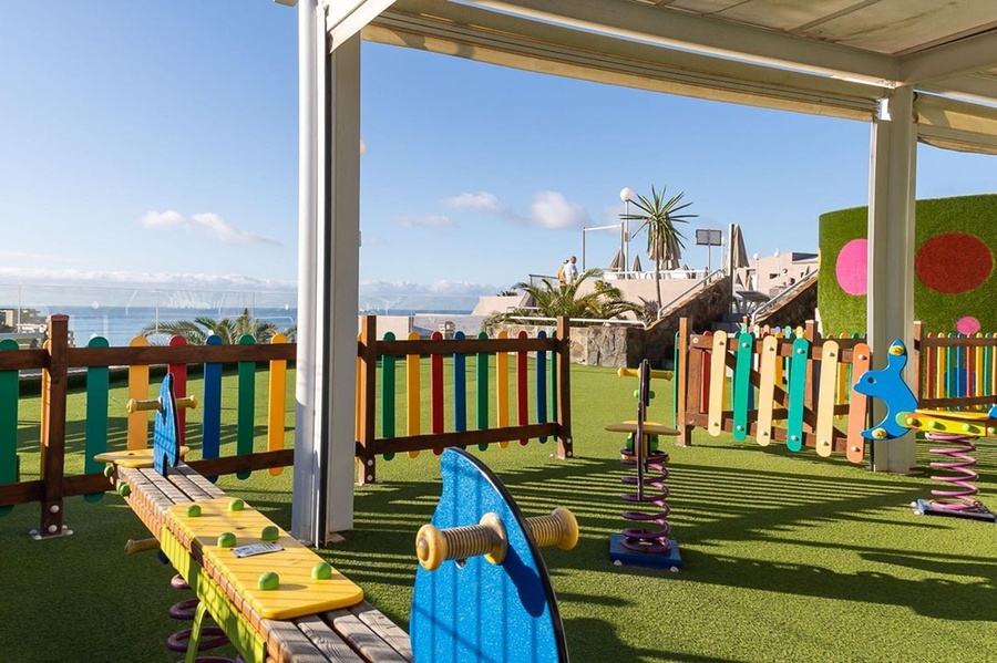 a purple and blue rocking horse on a spring in a playground