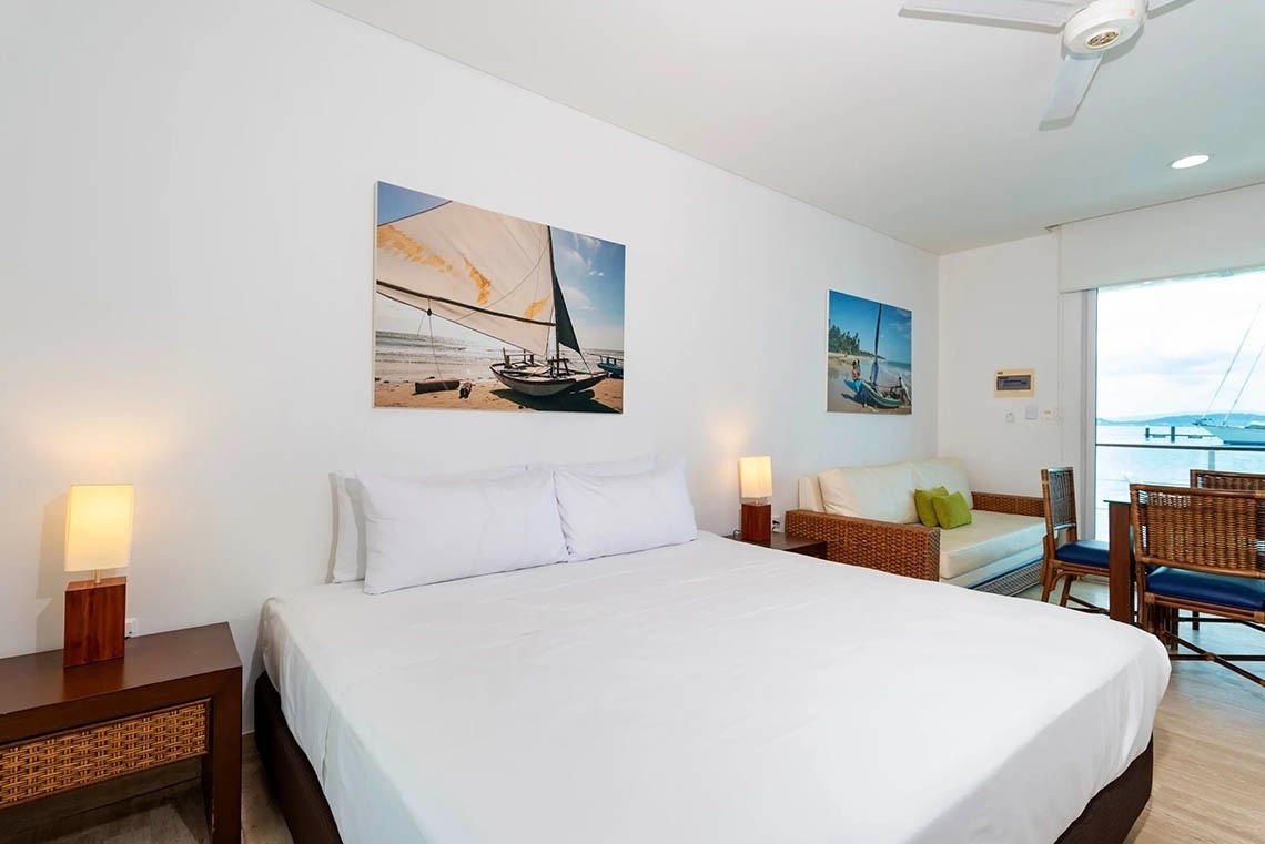 Bedroom with queen bed, sofa, and marina view at Marina Puerto Velero.