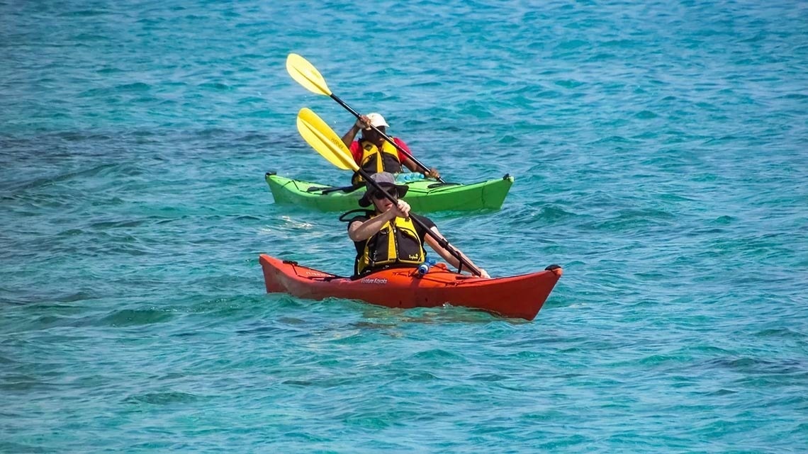 Kayakers enjoy turquoise waters near Marina Puerto Velero.