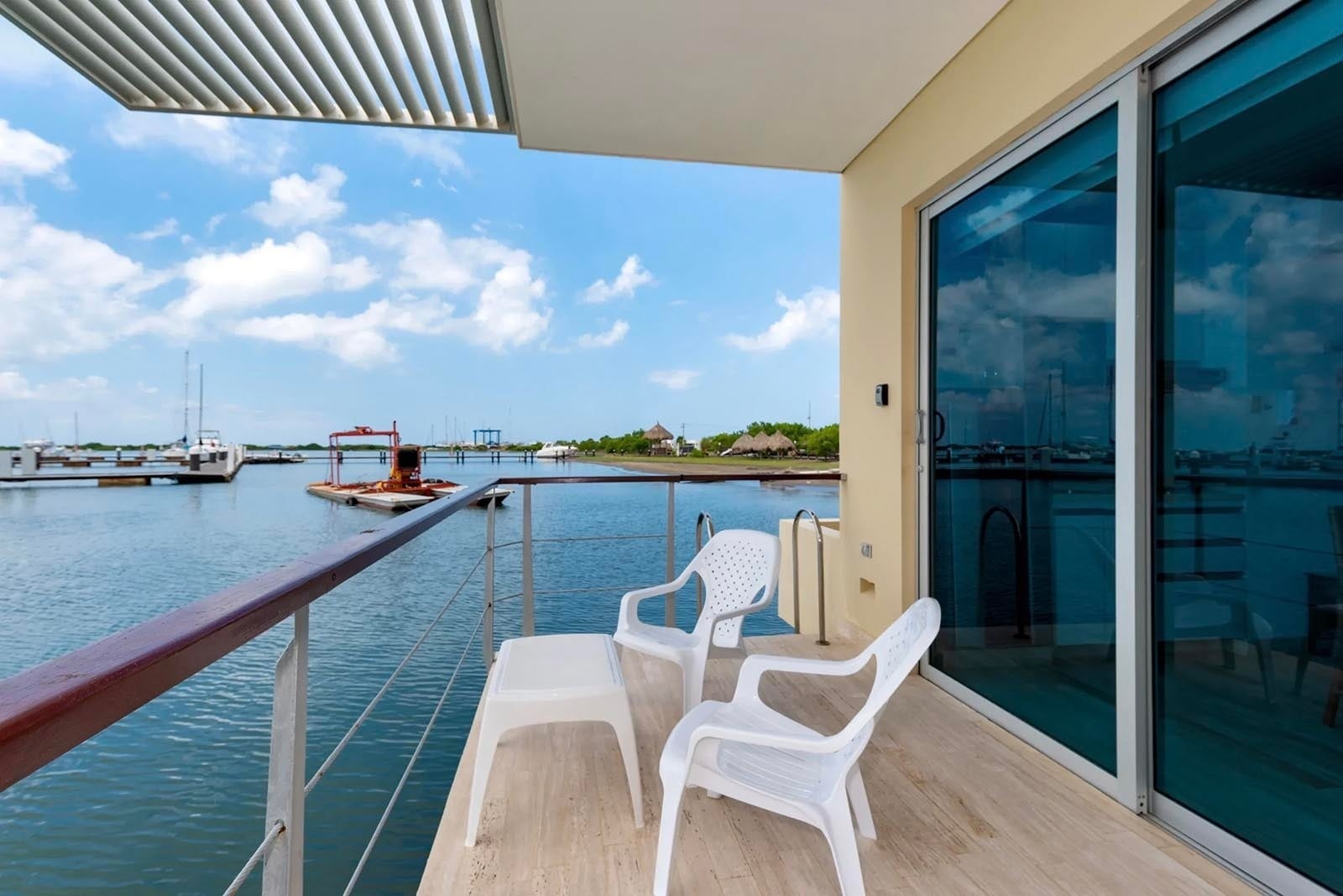 Balcón con vista a Marina Puerto Velero, sillas y mesa al aire libre.